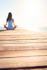Young Woman Doing Yoga On Pier