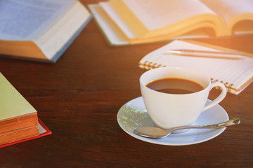 Coffee mug and book on old wooden table