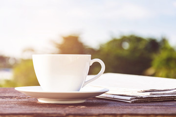 coffee cup clock and news paper on old wooden table