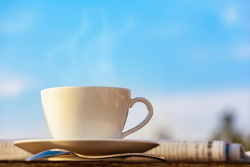 coffee cup clock and news paper on old wooden table