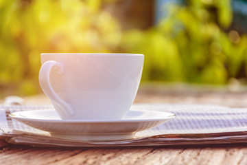 coffee cup clock and news paper on old wooden table