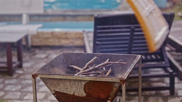 Person Waves Board to Kindle Flame in Grill