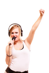 Fototapeta premium Woman singing to microphone wearing headphones