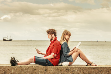 woman with smartphone man with tablet couple outdoor