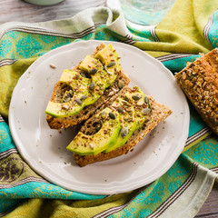 Avocado cereal sandwich for healthy snack with seeds on green napkin