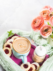 Obraz na płótnie Canvas Mug of coffee cookies and pink ranunculus flowers. Festive holiday breakfast. Mother valentine day