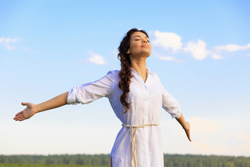 Young happy woman in green field, evening light