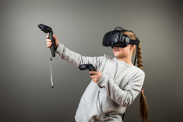 Child with virtual reality headset and joystick playing video games