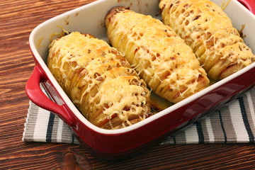 Sliced baked potatoes with cheese and bacon