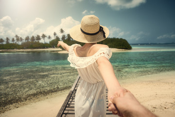 Follow me. Girl in white dress on the bridge. Maldives. Tropics. Ocean.