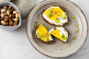 Sandwich with apricot jam and cottage cheese on a white plate, end with copy space