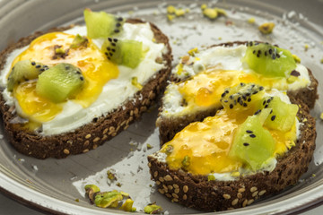 Sandwich with apricot jam and cottage cheese on a white plate, end with copy space
