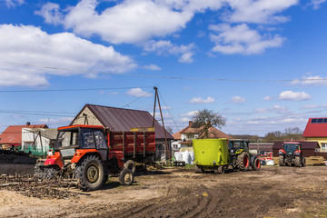 Agricultural machinery and equipment  near the garage and barn. Yard of a dairy farm. Podlasie,...