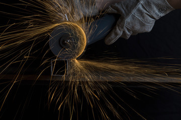 Angle grinder cutting a metal square tube making shower of sparks