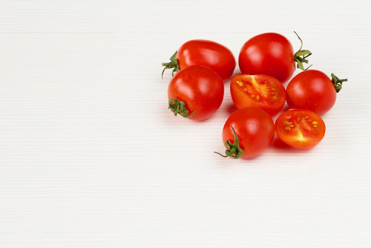 Cherry tomatoes on white wooden background.