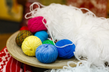 Fototapeta na wymiar Colorful yarn for knitting in green basket on wooden table on window background Crochet for knitting