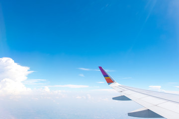 Fototapeta na wymiar Wing of an airplane flying above Clouds