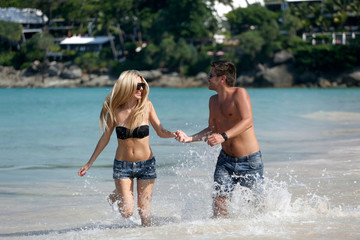 Fototapeta premium Young beautiful man and woman couple running along the beach.. Positive human emotions, feelings. Love story