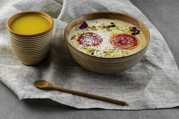 Healthy breakfast. Home made oatmeal porridge, goji berries, pumpkin and chia seeds in a ceramic bowl on white background.