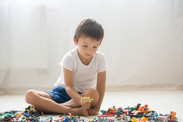 Cute little preschool children, boy brothers, playing at home with constructor blocks