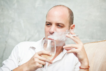 Man drinking wine and smoking 