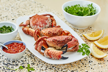 Three Boiled red crabs with two kinds of adjika sauce, green sauce and lemon