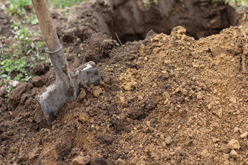 Improvement of the garden/ Old shovel next to the excavation pit on the lawn