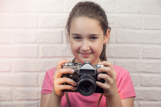 Young girl with an old photo camera