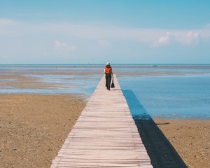 Traveler woman on the bridge to the sea background with vintage filter