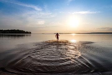 Fototapeta premium Young boy running in water