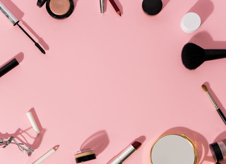 make up products and tools on pink background
