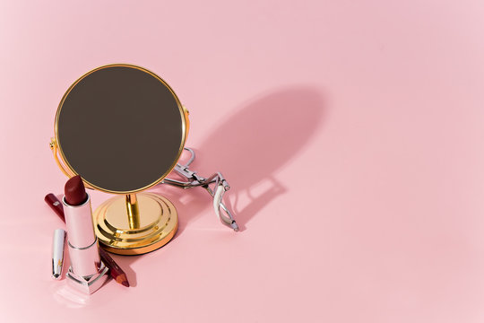 make up products and tools on pink background