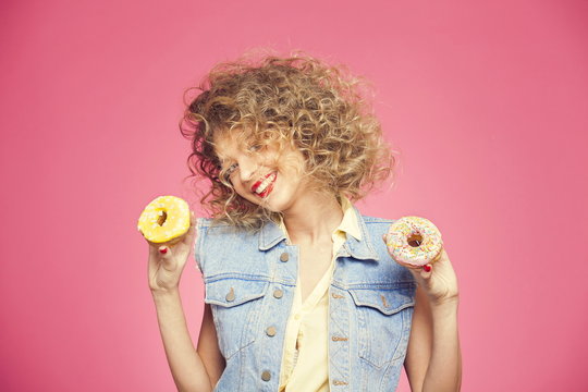 the girl with a smile holds in his hands a couple of donuts and smiling