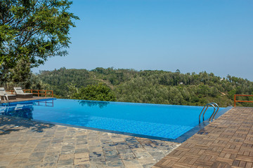Swimming pool on top of a hill station with mountain in the background, tamilnadu, India, April 29 2017