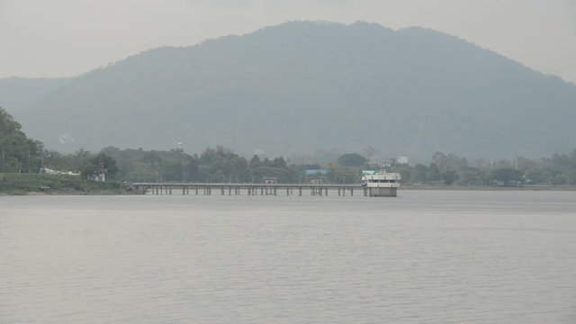 Wide angle view of a pier connected to a building in a lake. Bang Phra Reservoir, Si Racha, Thailand. Ungraded 1080p footage. Travel and environment concept.