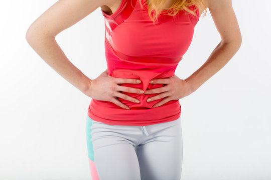 Side stitch - woman runner side cramps after running. Jogging woman with stomac side pain after jogging work out. Female athlete.