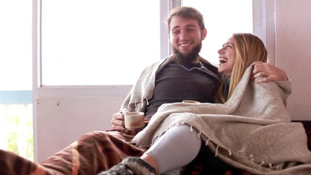 Couple In Cozy Clothes Laughing At Home In Winter