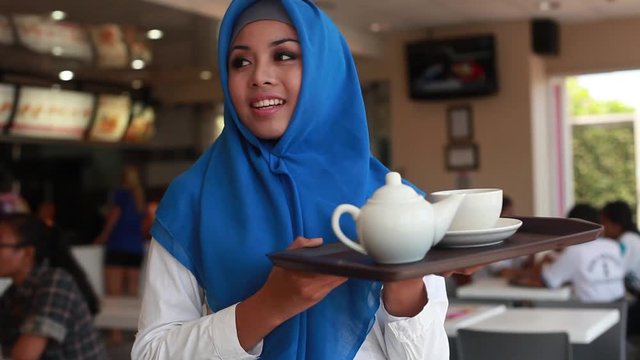 Young muslim woman serving tea