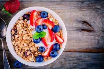 Healthy breakfast: bowl of granola with yogurt and berries