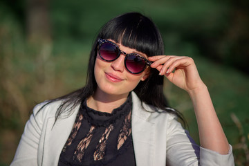 Beautiful young girl with black hair, sunglasses. Youth, happiness, summer sunny day, portrait