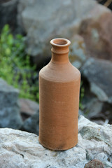 clay jug on a background of rock stones
