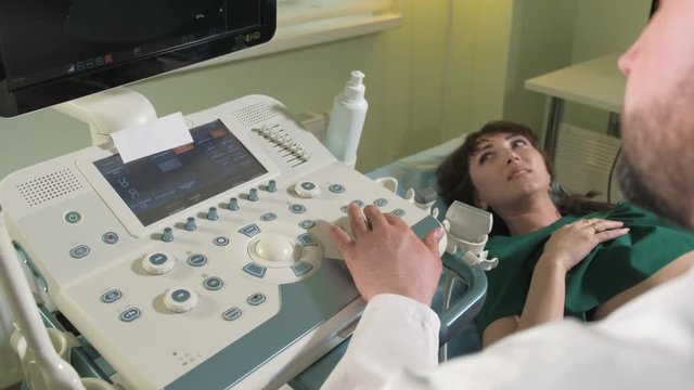 Doctor doing 3d ultrasound on belly of t woman in clinic 4k