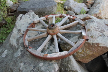 old wagon wheel on a rock