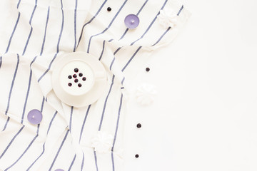 Composition with yogurt, blueberries, candles on white background. Flat lay, top view, copy space,