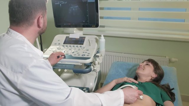 Doctor doing 3d ultrasound on belly of t woman in clinic 4k