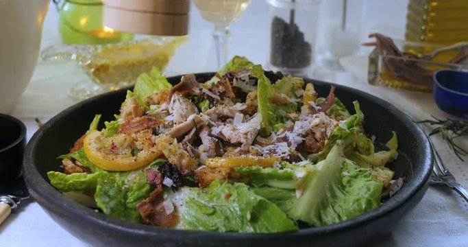 Sprinkling black pepper over a delicious Caesar's salad