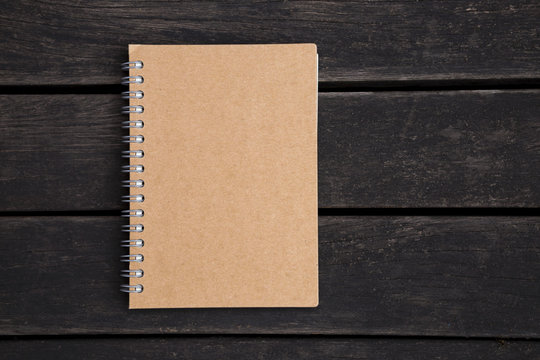 Brown notebook on dark wood background