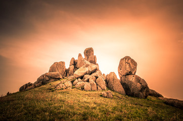 Fototapeta na wymiar Rocks formations in Dobrogea, Tulcea county, Romania. Naturally formed piles of large rocks in Macin Mountain the olders alps in Europe