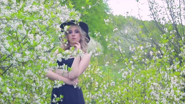 the girl in the black hat in the spring in nature