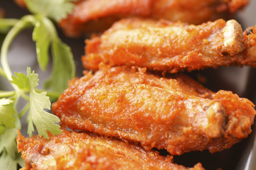 Close up Spicy Deep Fried Breaded Chicken Wings with Ranch and coriander on black plate